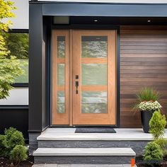 the front door of a modern home with two planters