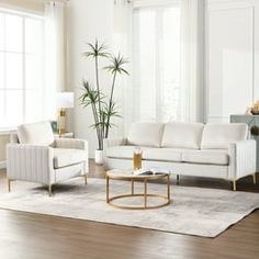 a living room with white furniture and wood floors