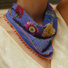 Periwinkle Bandana with Multi-Colored Flower Embroidery Styled on Model's Neck Bohemian Silk Scarf For Summer, Bohemian Scarves With Multicolor Embroidery, Festive Embroidered Silk Scarves, Spring Traditional Silk Scarf, Bohemian Scarves For Weddings And Festivals, Blue Bohemian Silk Scarf For Spring, Bohemian Blue Silk Scarf For Spring, Bohemian Silk Scarf, Multicolor Embroidered Bohemian Scarves