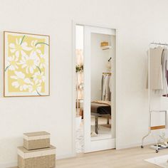 an empty room with clothes hanging on the rack and two boxes stacked next to it