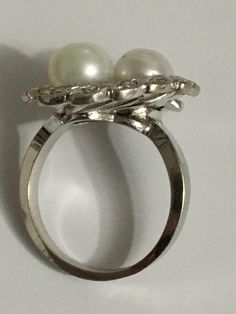 Details: A Unique and one of a kind Ring Handmade Vintage Ring Custom Made Ring (Estimated Late 1960's Early 1970's) 14Karat White Gold Ring Shank is nice and wide 2 Cultured Pearls in the Center One Pearl color is White the other has a silver tone color There are 12 diamond Stones around the Crown Estimate Total Weight .25ct Ring weight : 7.3 Grams Ring is appraised for the value of $2750 Since the following ring is Vintage no changes will be made to the ring Ring will be shipped via FEDEX seco Luxury Open Pearl Ring For Anniversary, Fine Jewelry White Gold Pearl Ring With Prong Setting, Exquisite Polished Formal Rings, Diamond White Platinum Pearl Ring For Anniversary, Platinum Pearl Ring In Diamond White For Anniversary, Elegant Rings With 17 Jewels, White Gold Pearl Ring With Prong Setting, Classic 14k White Gold Multi-stone Rings, Elegant Cluster Flower Ring For Anniversary