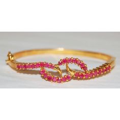 5-micron plated base metal with ruby stones. Pink Ruby Round Bracelets, Adjustable Ruby Bracelets For Formal Occasions, Adjustable Ruby Bracelet For Formal Occasions, Formal Adjustable Ruby Bracelets, Red Ruby Bangle As Gift, Elegant Gold Bracelets With Ruby, Elegant Gold Ruby Bracelets, Adjustable Elegant Ruby Bracelet, Formal Pink Ruby Bracelets