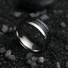 a black and white ring sitting on top of gravel