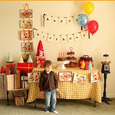 a little boy standing in front of a birthday table