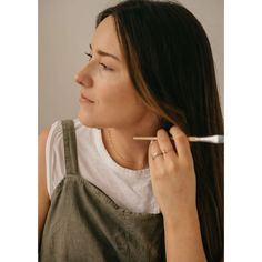 a woman is brushing her hair with an electric toothbrush