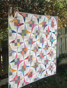 a quilt is displayed on the screen in front of a fence