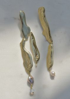 Named after a current of water, these brass dangle earrings are a uniquely elegant statement.   Textured brass combines with pearls and a single opaline glass bead.   Handmade in our Los Angeles studio. Details:-Left earring is 4 3/4"in height.-Right earring is 4"in height.-Sterling Silver posts and butterfly backs. Jewelry Mood Board, Water Texture, Sculptural Fashion, Face Jewellery, Family Jewels, Whimsical Fashion, Ear Cuffs, Contemporary Jewelry, Leaf Earrings