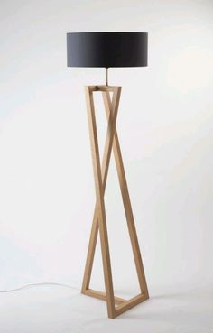 a wooden floor lamp with a black shade