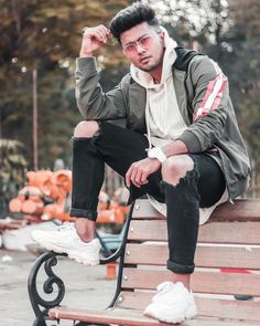 a man sitting on top of a wooden bench