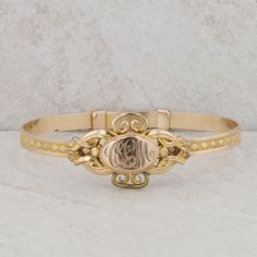 This children's gold plated bangle features an oval shaped monogram at its center, accented by filigree detailing, along with a diamond pattern around the rest of the bracelet. At the center, the initials "CLM" are engraved. This bracelet design is an adjustable to put on the wrist but it can only be worn at 5" inches. The bangle weighs 10.20 grams and measures in height 19.5mm. It can also be on a smaller ladies wrist but due to the size, it would more than likely be for a smaller child. Condit Classic Bracelets With Decorative Band As Gift, Adjustable Round Heirloom Gold Bracelet, Adjustable Heirloom Gold Bracelet, Adjustable Heirloom Gold Bangle Bracelet, Adjustable Victorian Bracelet For Anniversary, Adjustable Heirloom Yellow Gold Bangle, Adjustable Antique Gold Bracelet With Engraving, Antique Adjustable Gold Bracelet With Engraving, Classic Adjustable Cuff Bracelet With Intricate Design