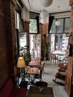 an empty restaurant with lots of tables and chairs in front of large windows that look out onto the street