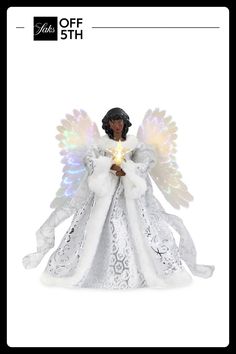 a white angel figurine holding a lit candle