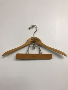 a pair of wooden clothes hangers on a white wall