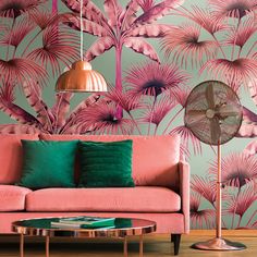 a living room with pink and green wallpaper, an orange table lamp and a pink couch