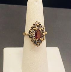 Beautiful 10k Gold ladies antique Gold garnet gemstone ring Size 6.5(Re-Sizing is available if needed) Please see my shop with hundreds of other incredible pieces of unique jewelry! We are a 100 year old, 5th generation, family business called Colonial Coin & Jewelers in Cleveland Ohio.  Satisfaction guaranteed or return for full refund. Vintage 14k Gold Filigree Ring With Gemstone, Antique 14k Gold Filigree Ring Collectible, Antique 14k Gold Ruby Ring Hallmarked, Antique 14k Gold Hallmarked Ruby Ring, Ornate Gold Ruby Ring, Antique Oval Filigree Ring, Antique Collectible Birthstone Ring, Antique 14k Gold Ruby Ring With Intricate Design, Vintage Garnet Ruby Ring With Intricate Design