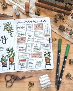 an open planner with lots of plants on it next to some scissors and other office supplies