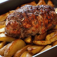 a piece of meat sitting on top of french fries in a pan next to potatoes