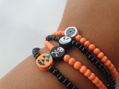 the bracelets are decorated with black, orange and white beads that have skulls on them