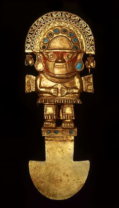 an old gold statue is displayed on a black surface with a white light in the background