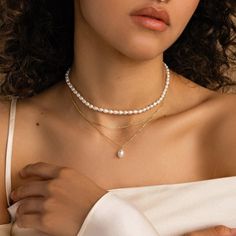 Our Duo Chain Pearl Necklace features a dainty choker paired with a lustrous pearl pendant necklace, creating a seamless layered look in one elegant piece. This unique design combines the timeless beauty of pearls with contemporary styling, perfect for an effortlessly chic, coordinated look that takes the guesswork out of layering. SKU: RR-NR218 Product Details Material: High Quality Solid 925 Sterling Silver Finish: 18K Gold ∙ Sterling Silver Featuring a Layered Pearl Necklace with a ~8.5in Cab Layers Necklaces Gold, Dainty Layered Jewelry, Classic White Necklace For Layering, White Pearl Charm Chain Necklace For Layering, Minimalist Pearl Chain Necklace For Layering, Elegant Pearl Choker Necklace With Clavicle Chain, Elegant Double Strand Pearl Necklace For Layering, Minimalist Layering Pearl Chain Necklace, Elegant Pearl Choker With Clavicle Chain