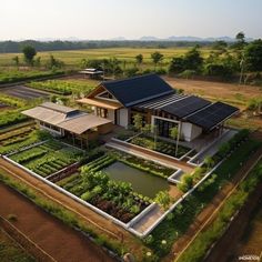 an aerial view of a farm house with solar panels on the roof and garden beds