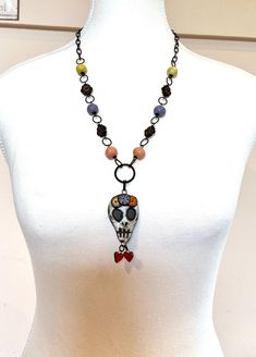 This listing is for one necklace as shown in the photos. The little heart charms, the coloured round beads, and the skull pendant are all handmade from clay. The black flower beads are Czech glass, and the chain is black Arte metal made by Vintaj Natural Brass.  The chain and beaded section measures 58cm or 22.83 inches, and the sugar skull pendant measures approximately 90mm or 3.54 inches. Please see the last photo.  I offer free shipping with tracking so take advantage while it lasts, you mig Sugar Skull Necklace, Czech Glass Necklace, Necklace Big, Artisan Necklace, Necklace Flower, Skull Necklace, Skull Pendant, Bohemian Necklace, Flower Beads