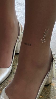 a close up of a person's foot with a small tattoo on the ankle