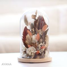 a clochet with flowers and feathers in it sitting on a white counter top