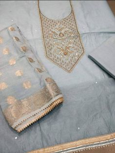 Item Overview ATHARVA Hand Embroidered Salwar Kameez w/Beautiful Embroidered Neck Grey/Banarsi Silk Dupatta/Latkan Tassel/Wedding/Bridal Trousseau Dno. CH1415 Fabric: * Shirt Chanderi Silk in Grey - 2.5 Mts, with Embroidered Neck * Dupatta: Banarsi Silk Dupatta - 2.5 Mts - (Motifs may wary) * Bottom Santoon Silk 2.5 Mts. Excusive Hand Embroidered Party Wear Punjabi Suit. Customization: * Fabrics Customization: Designs Can be made in different Fabrics. * Color Customization: Designs Can be made i Ceremonial Gota Work Kurta, Unstitched Gota Work Kurta For Ceremonial Occasions, Designer Chanderi Churidar For Transitional Seasons, Semi-stitched Raw Silk Set With Gota Work, Chanderi Churidar With Gota Work For Transitional Season, Ceremonial Chanderi Salwar Kameez With Gota Work, Designer Banarasi Silk Kurta With Gota Work, Embroidered Straight Kurta Fabric With Gota Work For Eid, Straight Kurta Embroidered Fabric With Gota Work For Eid