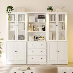 a living room filled with white furniture and bookshelves on top of each other