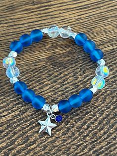 Blue and Clear beads with sliver accents and a star charm and blue gem  7 in or 17.78 cm Strong, Stretchy, and Durable     Very pretty bracelet for any occasion for any day Blue Star Charm Bracelet, Blue Handmade Star-shaped Beaded Bracelets, Blue Beaded Star-shaped Bracelets, Handmade Blue Star-shaped Bracelet, Handmade Blue Star Bracelet, Blue Bracelets With Star Charm And Round Beads, Blue Beaded Bracelets With Star Charm For Gift, Blue Bracelet With Star Charm As Gift, Blue Bracelets With Star Charm For Gift