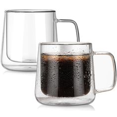 two glass mugs filled with liquid sitting next to each other on a white surface