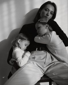 a woman sitting next to a child on top of a chair