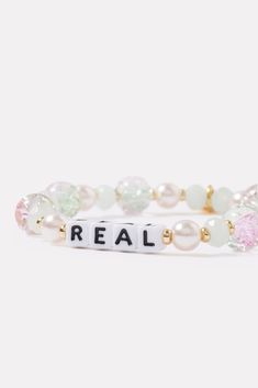 A wearable reminder of words to live by, this beaded bracelet by Little Words Project is handcrafted with “Real” lettering, faux pearls and glass beads, and stretch elastic for easy on-and-off. Alone or stacked, it makes the perfect gift for yourself or a friend. Little Words Project encourages you to wear your word to lift you up, and then pass it on to someone who needs it more. Each bracelet comes with a unique ID tag. Use this code to register your bracelet on the Little Words Project website to join the community and track your bracelet’s journey from person to person. Trendy Stretch Bracelet With Letter Print Beads, Trendy Stretch Bracelet With Letter Print And Round Beads, Casual Pearl Bracelet With Letter Beads As Gift, Casual Pearl Bracelet With Letter Beads For Gift, Project Website, Little Words Project, Your Word, Brand Style Guide, Shoe Size Conversion