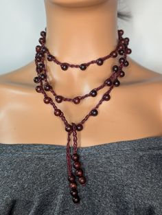 Discover the beauty of our Long Crochet Blood Sandalwood Beaded Necklace, meticulously handcrafted for the bohemian soul. This stunning piece features a harmonious blend of blood sandalwood beads and intricate crochet work, creating a unique and timeless accessory. Perfect for layering or wearing solo, this necklace adds a touch of elegance and earthy charm to any outfit. Ideal as a thoughtful gift for her, this artisanal necklace will surely become a cherished favorite. Embrace the allure of handmade jewelry and elevate your style with this exquisite piece. This beautiful handmade crochet beaded Necklace is made using aromatic sandalwood beads, waxed cord and Measures 60 inches and is a tie-on necklace no clasp and could be wrapped several ways for a different look every time, Simple yet Bohemian Jewelry With Wooden Beads In Natural Color, Natural Bohemian Jewelry With Wooden Beads, Bohemian Natural Wooden Beads Jewelry, Bohemian Brown Lariat Beaded Necklaces, Bohemian Wood Necklaces Perfect For Gifts, Bohemian Wood Necklace For Gift, Bohemian Wood Necklace Perfect As A Gift, Bohemian Wood Necklace As Gift, Bohemian Wooden Necklace For Gift