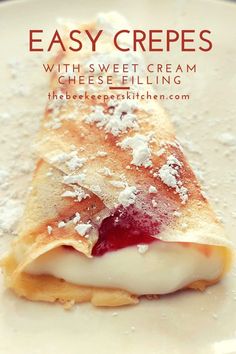 an easy crepe with sweet cream and cheese filling on a white plate topped with powdered sugar