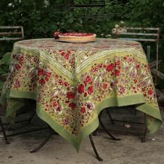 a table with a cloth on it in the middle of some bushes