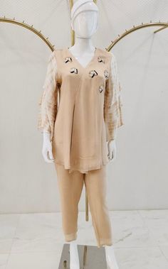 A peach colored kurta and palazzo set, curated for a casual evening affair, is fashioned from luxurious fabric to guarantee comfort. The short kurti, adorned with embroidered buttis scattered around the neck and featuring elbow-length 3 tier sleeves, exudes an understated elegance. The ensemble is impeccably completed by plain straight pants in matching colors, presenting a cohesive and sophisticated look.  Note: Colors may slightly vary due to photographic lighting. Please contact us if you hav Peach Kurti, Kurta And Palazzo, Short Kurti, Kurta Design, Kurti Set, Palazzo Set, Casual Evening, Whatsapp Message, Matching Colors