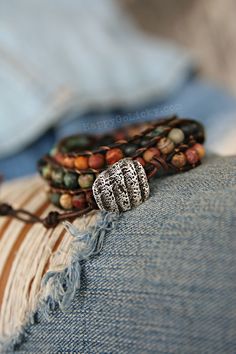 "Matte Stone Beaded Leather Wrap Bracelet: Our exclusive NEW boho wrap bracelet is created from dark brown leather and genuine 6mm Picasso jasper natural stone beads in desert landscape shades that are matte instead of shiny for a modern boho chic look. So intriguing and totally different. The end is finished with a rustic shell fragment button clasp replicated in sterling silver that can be fastened into 1 of 3 loops for adjustability to FIT WRISTS ranging from 5 3/4\"-7\" (14.6cm - 18cm). This Hippie Beaded Bracelets With Natural Stones For Festivals, Hippie Beaded Wrap Bracelet, Festival Artisan Wrap Bracelet With Colorful Beads, Adjustable Earthy Hand Wrapped Bracelet, Earthy Adjustable Hand Wrapped Bracelet, Hippie Adjustable Wrap Bracelet With Round Beads, Hippie Wrap Bracelet With Round Beads, Adjustable Hippie Wrap Bracelet With Round Beads, Hippie Style Adjustable Wrap Bracelet With Round Beads