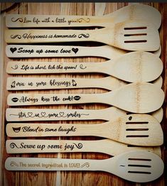 five wooden spoons with different sayings on them sitting on top of a table