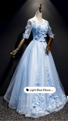 a light blue dress with flowers on the skirt is displayed in front of a mannequin