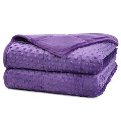 the purple blanket is folded on top of each other, with dots all over it