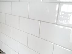 a white tiled wall in a kitchen