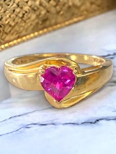 "Beautiful Estate 14k Yellow Gold MOM Pink Spinel Heart Ring Size 7 Very pretty ring crafted of solid 14k Yellow Gold! * The beautiful solid 14k gold band has \"MOM\" cutout on both top and bottom of ring! * Incredibly BEAUTIFUL heart shaped bright pink heart center stone! * Weighs 3.8 grams total. * Size 7 Shipped FAST AND FREE, with insurance in a gift box! I guarantee item to be as described and pictured - please shop with confidence :)" Gold Heart Ring With Center Stone For Anniversary, Hallmarked Heart Cut Promise Ring, Gold Heart Cut Gemstone Ring, Gold Ring With Gemstone In Heart Cut, Gold Heart-shaped 14k Gold Ruby Ring, 14k Gold Heart-shaped Ruby Ring, Heart-shaped Yellow Gold Birthstone Ring, Gold Heart-shaped Ruby Ring In 14k Gold, Heart-shaped Ruby Ring In 14k Gold