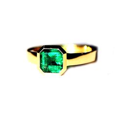 a close up of a ring with a green stone on it's center piece