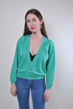 Add a touch of vintage charm to your wardrobe with this green minimalist buttons cardigan! Made from comfortable cotton, this cardigan features a unique design that is perfect for adding a retro flair to your outfit. Please note that this is a vintage item, so it may have some defects. To ensure a proper fit, please refer to the measurements below: Sleeve: 46cm / 18.11 inches (measured from armpit to end of sleeve) Width: 52cm / 20.47 inches Length: 52cm / 20.47 inches These measurements are tak Vintage V-neck Cardigan For Layering, Green Cotton Long Sleeve Cardigan, Green V-neck Cardigan For Layering, Vintage Sweater For Spring Layering, Green Button-up Cotton Cardigan, Green Cotton Button-up Cardigan, Classic Green Cotton Cardigan, Green Cotton V-neck Cardigan, Trendy Green Cardigan For Layering