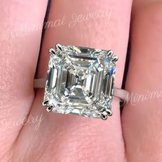 a woman's engagement ring with an emerald cut diamond