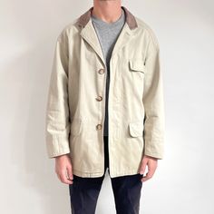 Cool, classy, casual men's vintage jacket in neutral stone beige and brown leather collar. It fastens with hidden buttons, has three front pockets plus one in the inside and is lined with a panel of beautiful plaid. The coat is lightweight, yet fairly sturdy, made from heavy weight canvas with a striped textured weave. It's a smart, neutral wardrobe staple for spring/autumn, to go with smart trousers or jeans. Made in Philippines by St. Michael. Shell: 100% cotton + 100% leather; Lining: 65% pol Classic Beige Outerwear With Corduroy Collar, Classic Cream Outerwear With Flap Pockets, Classic Outerwear With Corduroy Collar, Classic Outerwear With Corduroy Collar And Button-up, Classic Button-up Outerwear With Corduroy Collar, Vintage Khaki Outerwear With Welt Pockets, Classic Cream Outerwear With Welt Pockets, Classic Single-breasted Sport Coat For Everyday, Classic Beige Utility Jacket With Flap Pockets