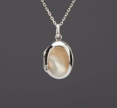 An oval sterling silver photo locket necklace with an oval bezeled mother of pearl on the front: 1. One shining, highly polished solid sterling silver locket, 19 x 14 x 7.6 mm (measured without the bale) and weighs 3.4 grams Its front has a piece of mother of pearl (16 x 11 mm) set in a raised bezel. Its back is plain and can be engraved with initials or a few words. 2. It has two photo slots insides. Photo insertion service available (selected through the pulldown menu). If you choose this serv Locket Necklace Silver, Silver Locket Necklace, Picture Locket, Valentine Gifts For Girlfriend, Sterling Silver Locket, Oval Locket, Photo Locket Necklace, Memory Locket, Silver Locket