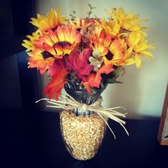 a vase filled with lots of flowers on top of a table